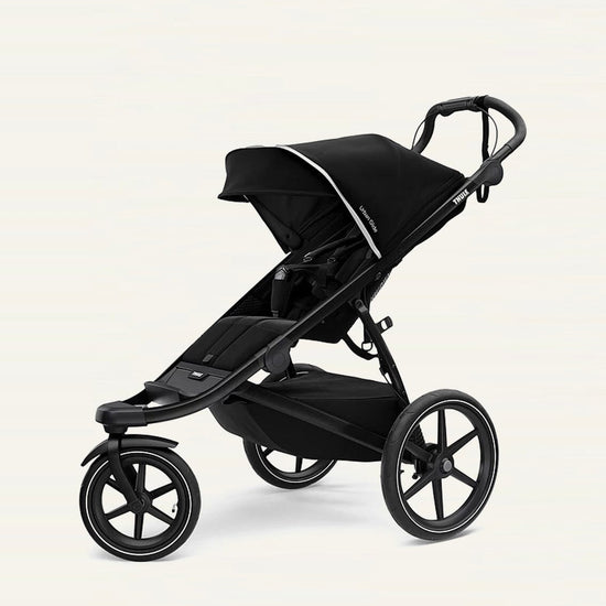 A black Thule Urban Glide 3-wheel stroller with a compact fold feature, designed for use on various terrains. Thule Urban Glide rental on Baboodle